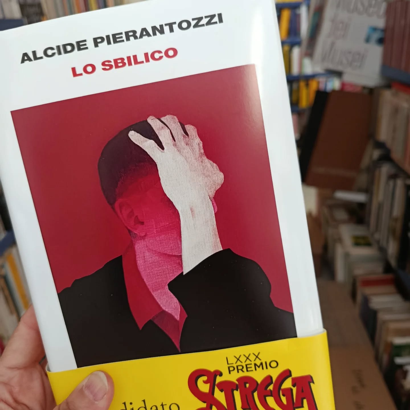 "Lo sbilico"
di Alcide Pierantozzi
Einaudi editore 

Finalista al Premio Strega 2026

«Il problema era che io aspettavo i corvi, e invece arrivavano i pensieri». Cosa accade quando la realtà si smaglia, e lascia entrare l'allucinazione? Quando la paura ti avvinghia e si accorcia il respiro? Quando l'unico modo che hai per stare al mondo è vivere su un precipizio, nello «sbilico» delle cose? Alcide Pierantozzi si è immerso in quel precipizio, e ne è uscito stringendo tra le mani un libro unico, letterario e ossessivo, capace di raccontarci per la prima volta in modo crudo e vero, “da dentro”, un male che è di molti. Una storia di una potenza disarmante, che urtica e lenisce insieme, e che una volta iniziata pretende di essere letta fino all'ultima parola. O bevuta fino all'ultima goccia, come una medicina. Alcide ha quarant'anni, a volte dorme ancora con sua madre, prende sette pasticche al giorno (cinque la mattina e due dopo cena), ed è considerato «un paziente lucido, vigile, collaborativo, dall'eloquio fluido». È un essere umano «difettoso» tra i tanti, ma i suoi difetti stanno tutti dentro quattro pagine di diagnosi controfirmate da uno dei più famosi psichiatri italiani: «disturbo bipolare», «spettro dell'autismo», «dissociazione dell'io», «antipsicotici», «pensieri di mancata autoconservazione»... Dal suo esilio in una cittadina dell'Abruzzo, dove ogni cosa sembra da sempre uguale a sé stessa, Alcide ci racconta il tempo melmoso delle sue giornate. Le ore in spiaggia, o a sfinirsi in palestra, dove va per riguadagnare in muscoli quello che ha perso in lucidità mentale. Soprattutto ci racconta – con tutta la chimica che ha in testa – cosa accade quando l'equilibrio psichico s'incrina: l'innesco della paranoia, la percezione che si sdoppia, il modo in cui il tempo fermo di un'attesa non è mai davvero fermo, perché è lì che arrivano i pensieri. 

#losbilico #alcidepierantozzi #einaudieditore #finalistapremiostrega2026